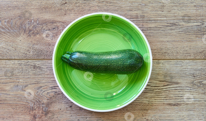 Скачать зеленый кабачок-цукини с кожурой с рисунком на зеленой тарелке на фотосток Ozero