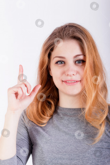Скачать Молодая счастливая женщина тычет пальцем вверх в copyspace фотосток Ozero