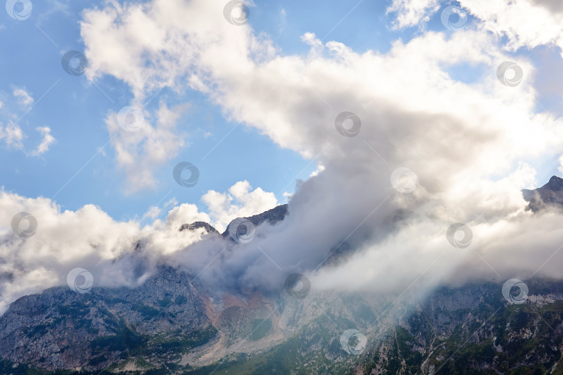 Скачать горный пейзаж с солнечным лучом, пробивающимся сквозь облака фотосток Ozero