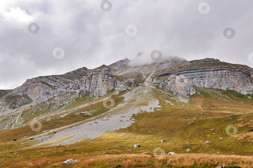 Скачать красивый осенний горный пейзаж со скалистой вершиной в облаках фотосток Ozero