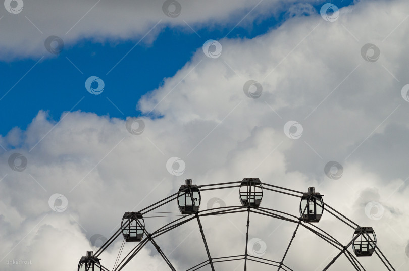 Скачать Фон с пространством для текста. Вершина колеса обозрения и небо с облаками фотосток Ozero
