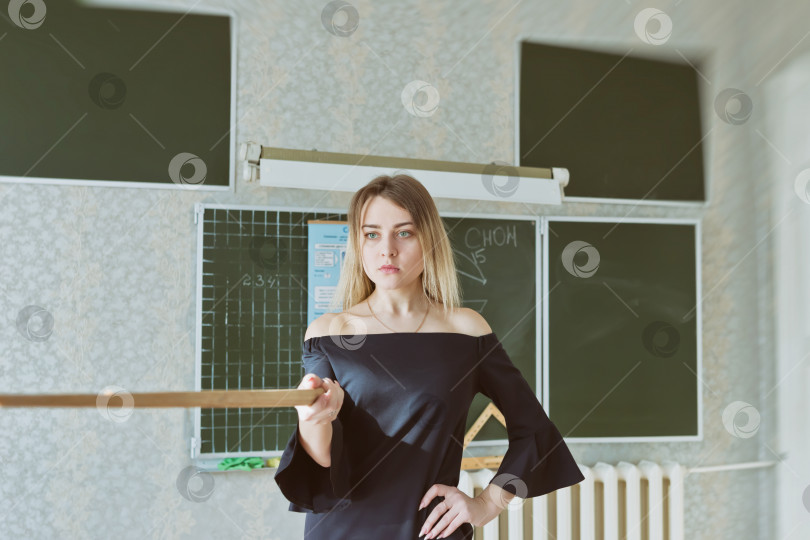Скачать Молодая стройная красивая блондинка учительница в черном платье фотосток Ozero