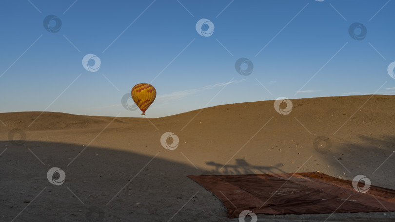 Скачать Яркий воздушный шар поднимается над песчаной дюной. фотосток Ozero