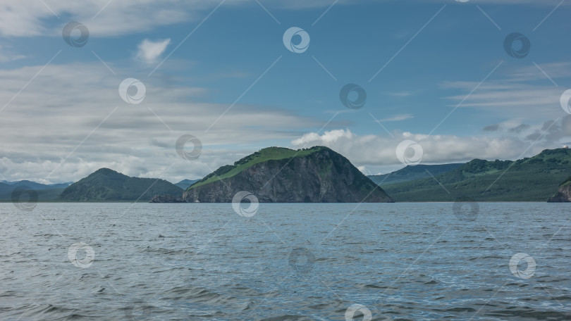 Скачать Живописное побережье Камчатки на фоне голубого неба и облаков. фотосток Ozero