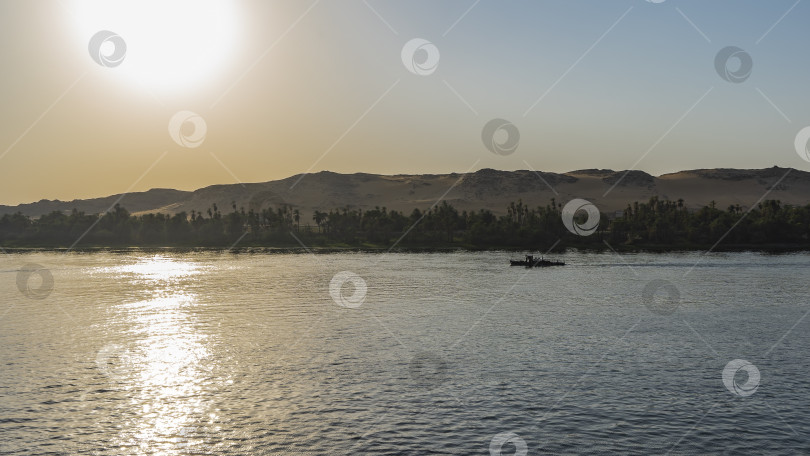 Скачать Вечер в Египте.  Лодка плывет по спокойной реке. фотосток Ozero