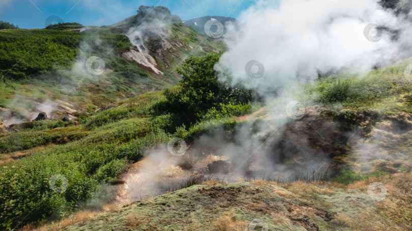 Скачать Пар и дым поднимаются из фумаролы на склоне холма. фотосток Ozero