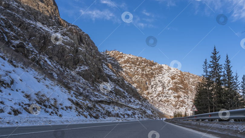 Скачать Шоссе проходит вдоль гор с крутыми заснеженными склонами. фотосток Ozero