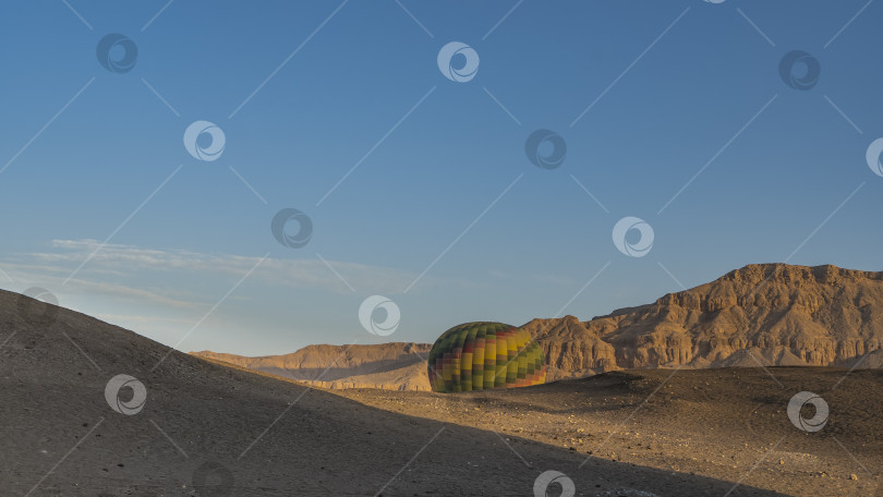 Скачать Яркий воздушный шар поднимается из ущелья над пустынным плато. фотосток Ozero