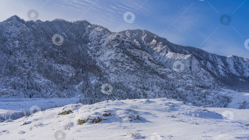 Скачать Живописный заснеженный горный хребет на фоне голубого неба. фотосток Ozero