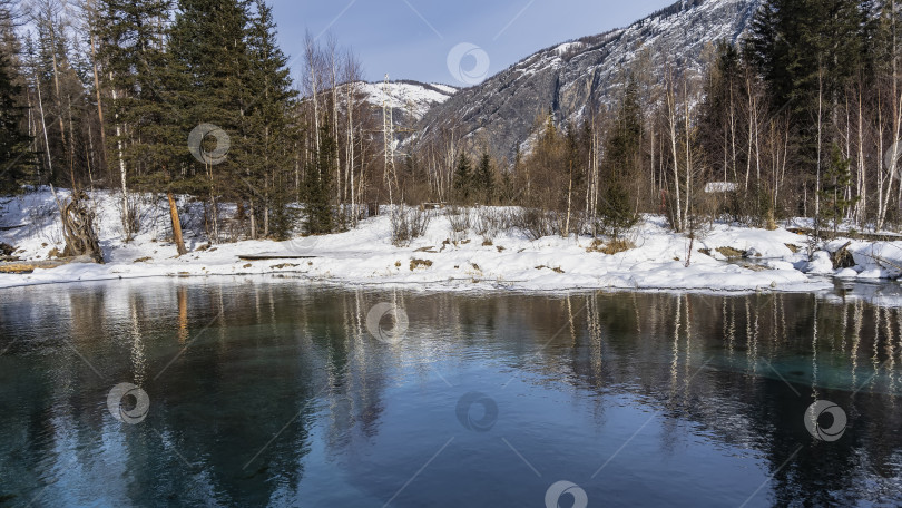 Скачать Незамерзающее озеро в зимнем лесу. фотосток Ozero