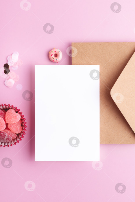 Скачать Белый лист бумаги, праздничные сладости на розовом фоне, вид сверху. фотосток Ozero