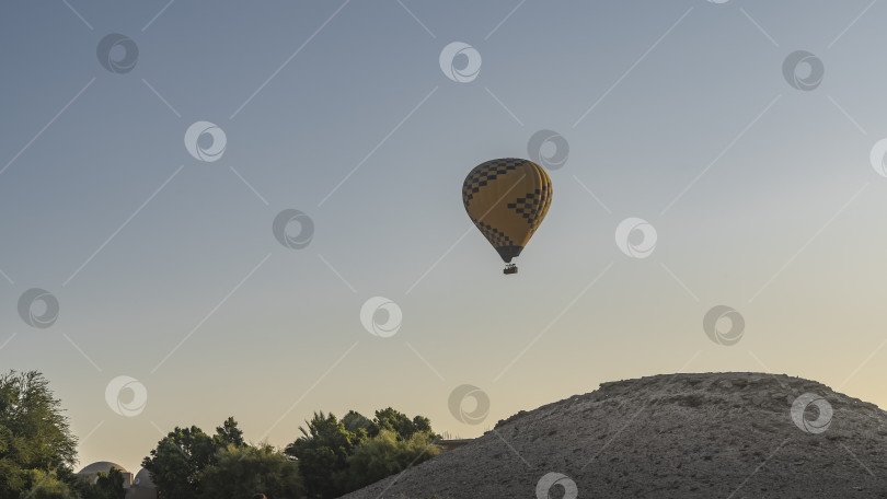 Скачать Воздушный шар летит в ясном голубом небе. фотосток Ozero