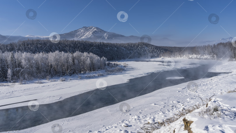 Скачать Незамерзающая река течет по заснеженной долине. фотосток Ozero