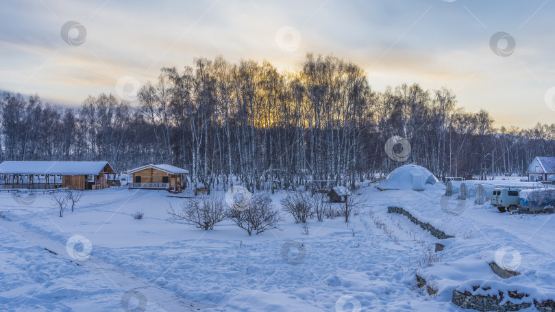 Скачать Туристический лагерь зимой. Деревянные дома стоят в снегу. фотосток Ozero