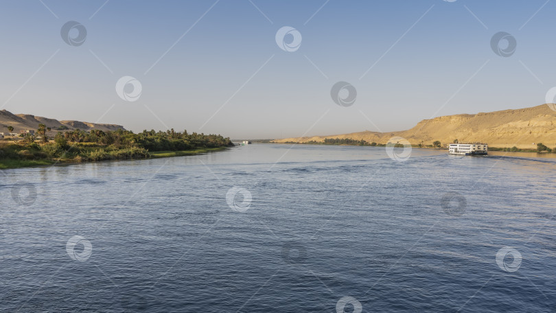 Скачать Река Нил течет спокойно. На голубой воде виден круизный лайнер= фотосток Ozero