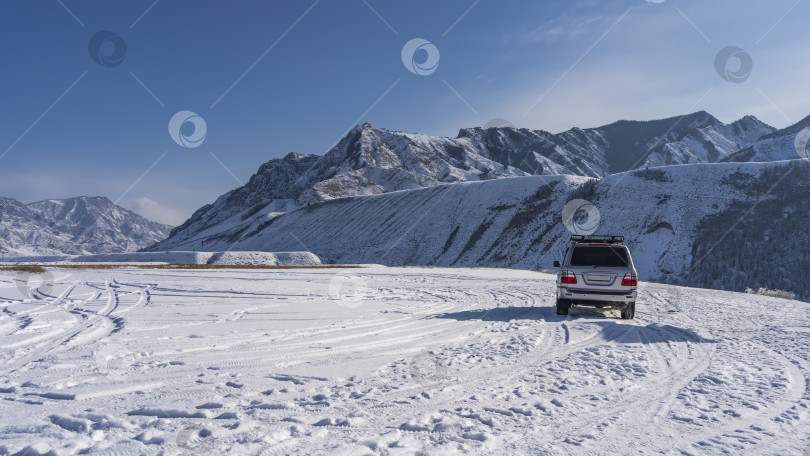 Скачать Автомобиль припаркован на заснеженном высокогорном плато. фотосток Ozero