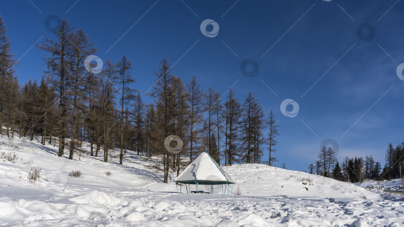 Скачать Беседка стоит в заснеженной долине среди сугробов. фотосток Ozero