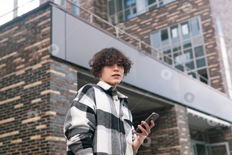 Скачать молодой человек с телефоном на фоне городских зданий фотосток Ozero