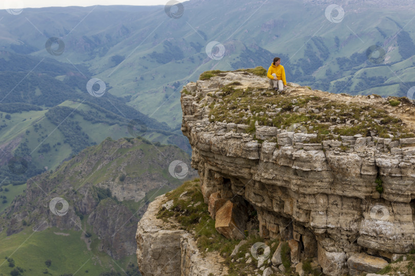 Скачать Вид на горный утес плато Бермамыт с сидящим на нем человеком фотосток Ozero