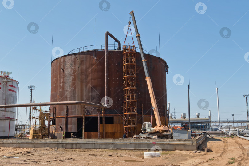 Скачать Ремонтные работы по замене нижних ремней старого ржавого резервуара для хранения нефтепродуктов фотосток Ozero
