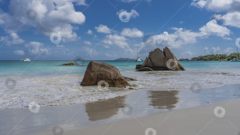 Скачать Живописные гранитные скалы на тропическом пляже омываются океаном. фотосток Ozero