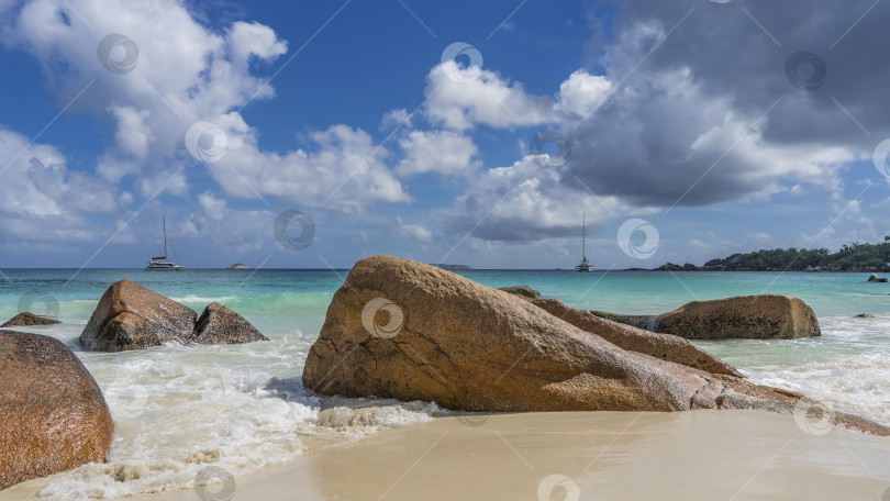 Скачать Живописные валуны на тропическом пляже омываются волнами. фотосток Ozero