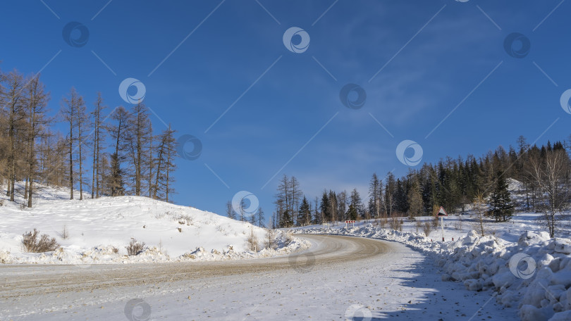 Скачать Шоссе петляет по заснеженной долине между холмами. фотосток Ozero