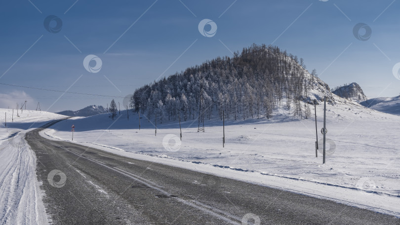 Скачать Шоссе проходит через заснеженную долину. фотосток Ozero