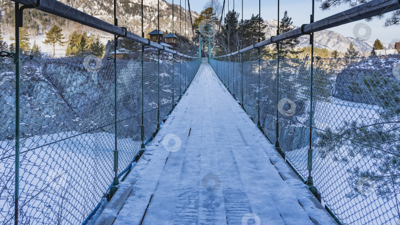 Скачать Подвесной пешеходный мост с решетчатыми перилами ведет к уединенному монастырю фотосток Ozero