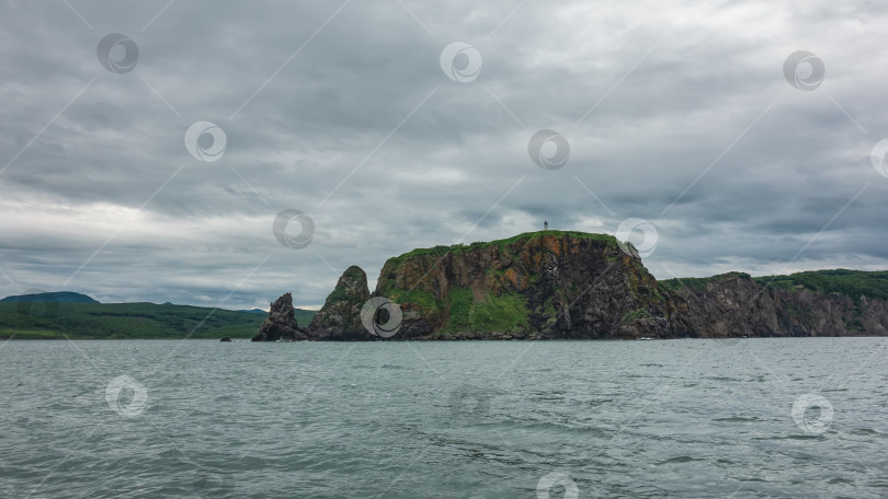 Скачать Суровое побережье Камчатки на фоне пасмурного неба и океана. фотосток Ozero