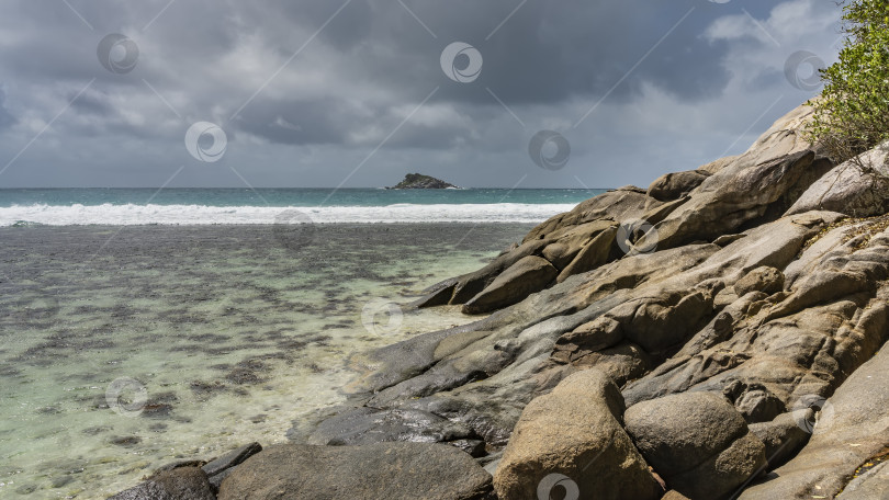 Скачать Скалистый склон тропического острова на фоне бирюзового океана. фотосток Ozero