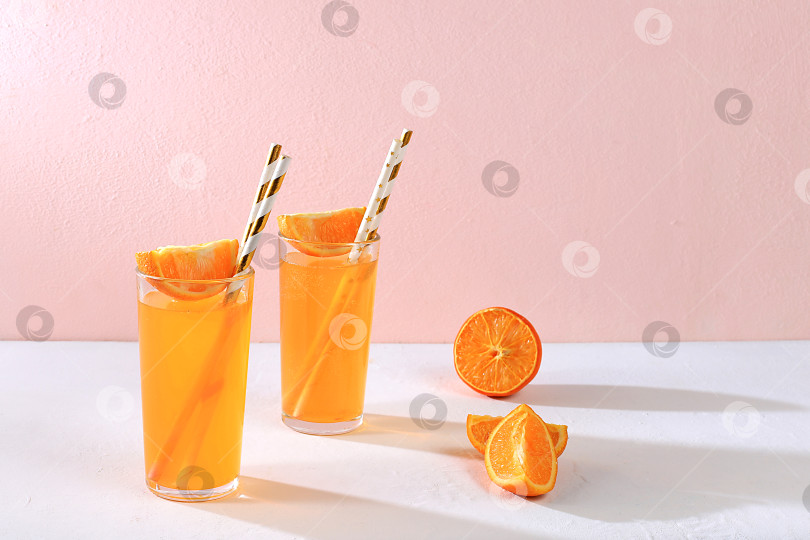 Скачать Современный натюрморт с цитрусовыми, апельсиновым соком и ингредиентами на цветном розовом фоне с длинными резкими тенями, концепция минимальной детокс-диеты фотосток Ozero