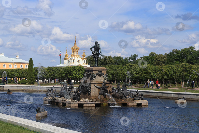 Скачать Россия, Санкт-Петербург, Петергоф, 8 июля 2019 года. На фотографии изображен фонтан "Нептун" в Верхнем парке Государственного музея-заповедника "Петергоф", Главная придворная церковь фотосток Ozero