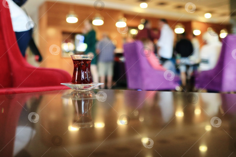 Скачать Чашка турецкого чая на блюдце стоит на стеклянном столике фотосток Ozero