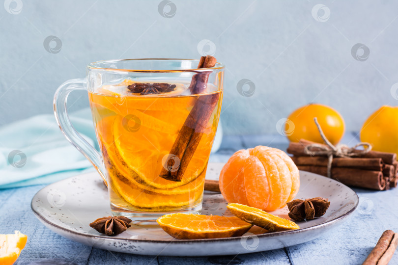 Скачать Мандариновый чай с корицей и анисом в чашке на столе. Анти фотосток Ozero