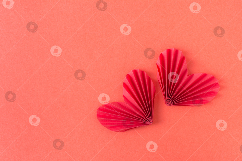 Скачать Два красных бумажных сердечка-оригами на красном фоне. Монохромный кон фотосток Ozero