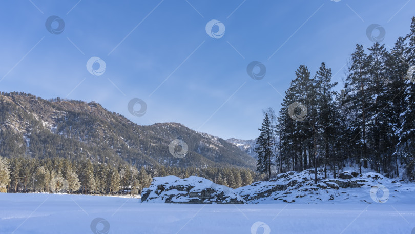 Скачать В долине видны валуны, покрытые слоем снега. фотосток Ozero