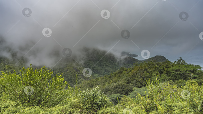 Скачать Низкие дождевые облака и туман нависли над горами. фотосток Ozero