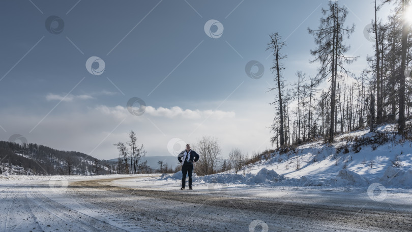 Скачать Шоссе изгибается вдоль заснеженного склона холма. фотосток Ozero