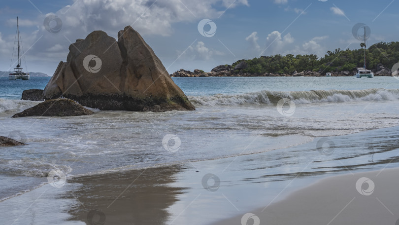 Скачать Живописная гранитная скала в полосе прибоя на тропическом пляже. фотосток Ozero