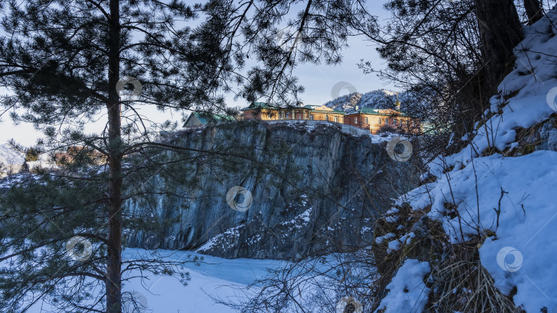 Скачать На скалистом острове с крутыми склонами видны деревянные домики уединенного монастыря. фотосток Ozero
