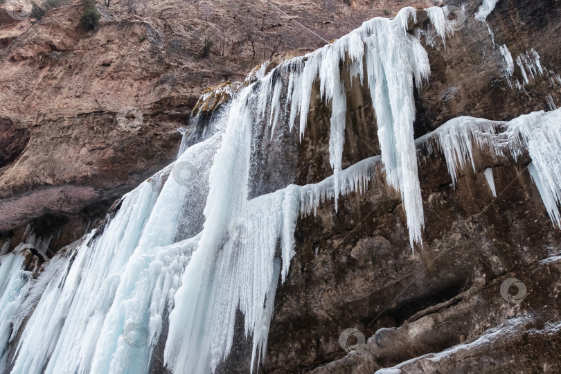 Скачать Большие замерзшие сосульки на месте водопадов в горной местности фотосток Ozero
