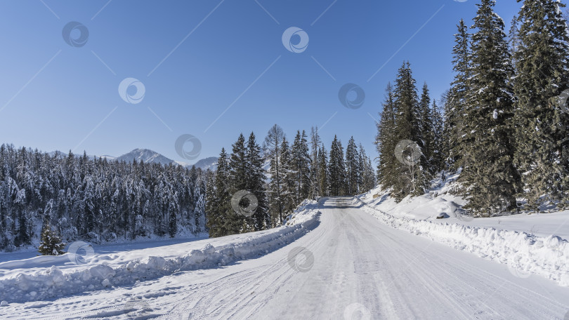 Скачать Дорога, протоптанная в снегу и расчищенная, взбирается на холм. фотосток Ozero