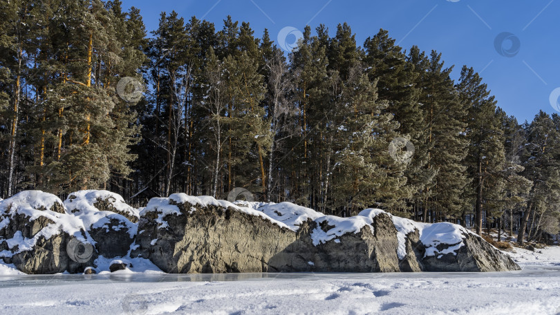 Скачать Огромные живописные валуны лежат на берегу замерзшей реки. фотосток Ozero