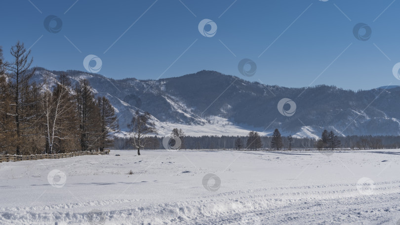 Скачать На утоптанной дороге в снегу видны следы шин. фотосток Ozero