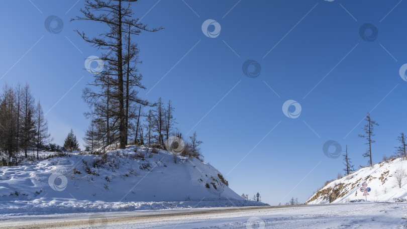 Скачать Зимняя дорога петляет между холмами. фотосток Ozero