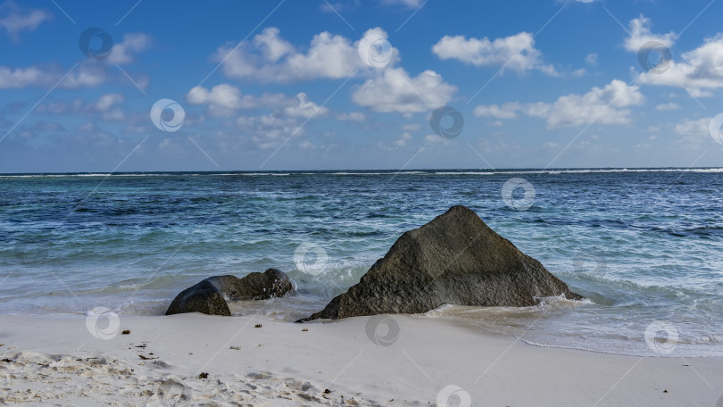 Скачать Живописные гранитные валуны на тропическом пляже омываются волнами фотосток Ozero