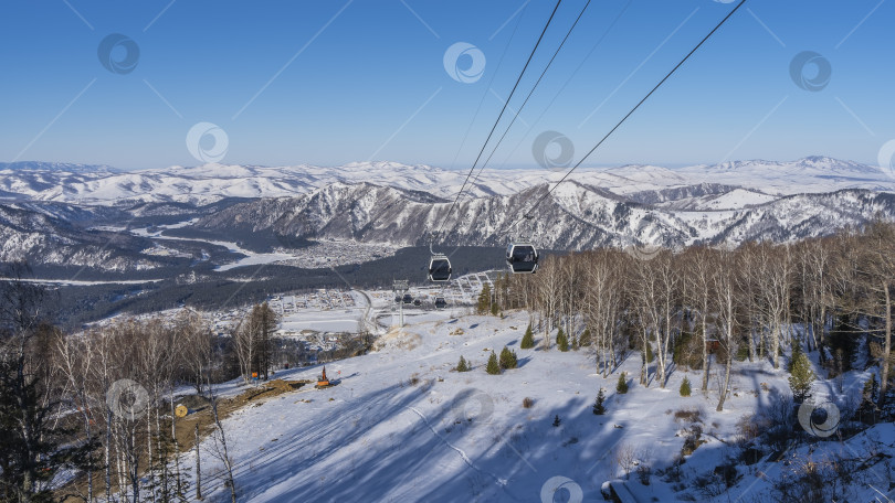 Скачать Канатная дорога проходит над заснеженной долиной. фотосток Ozero