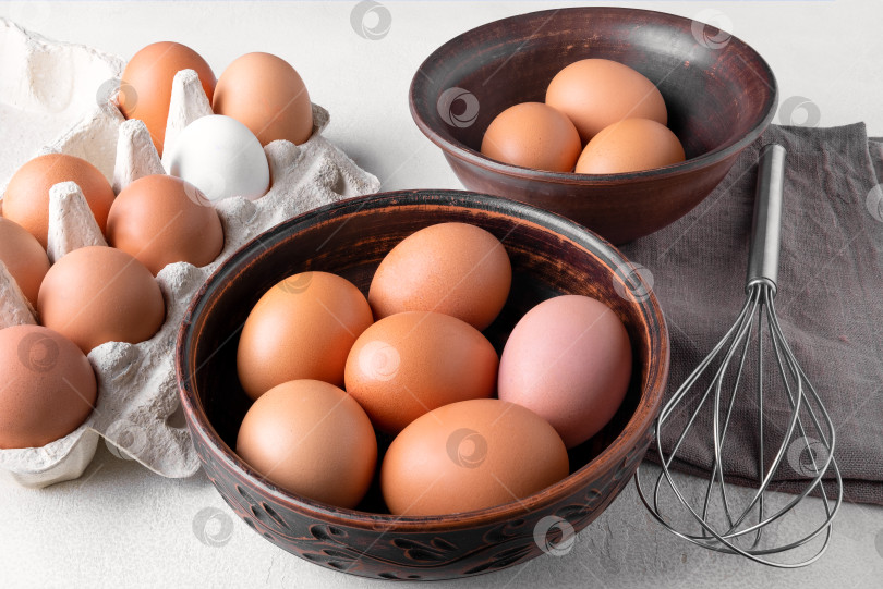 Скачать Куриные яйца в картонной упаковке и в миске фотосток Ozero