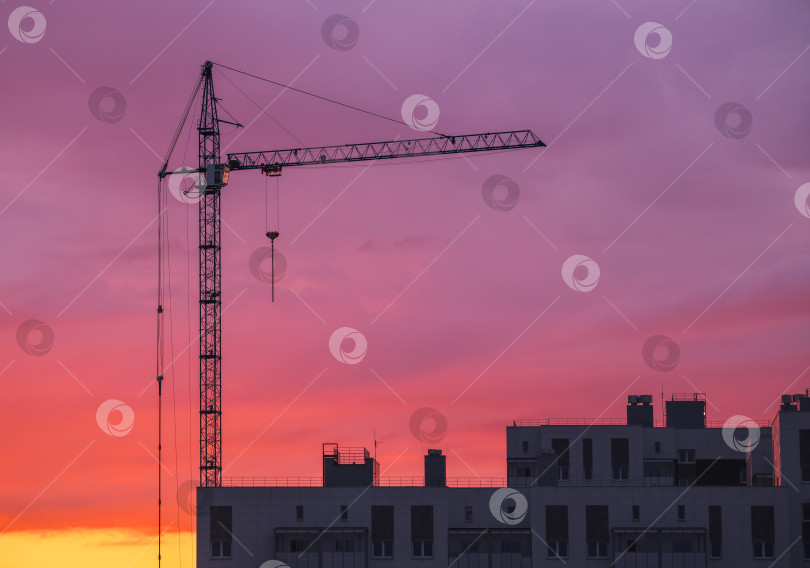 Скачать Кран и строящееся здание на фоне оранжевого и красного фотосток Ozero